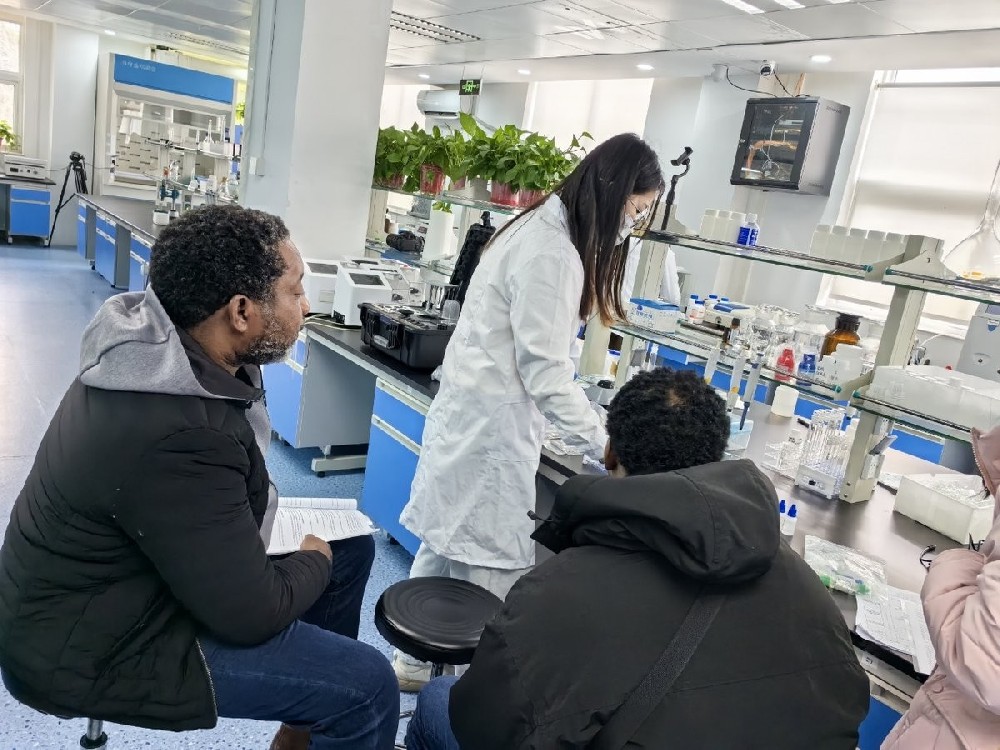 Zambian agronomists observing a soil nutrient analyzer demonstration in the laboratory