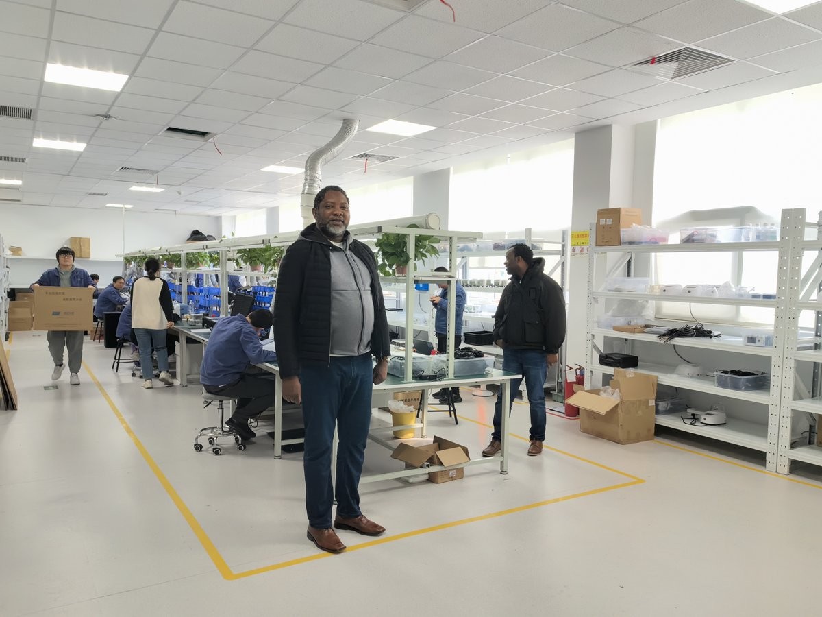Zambian project manager walking through the HM Instruments instrument production workshop