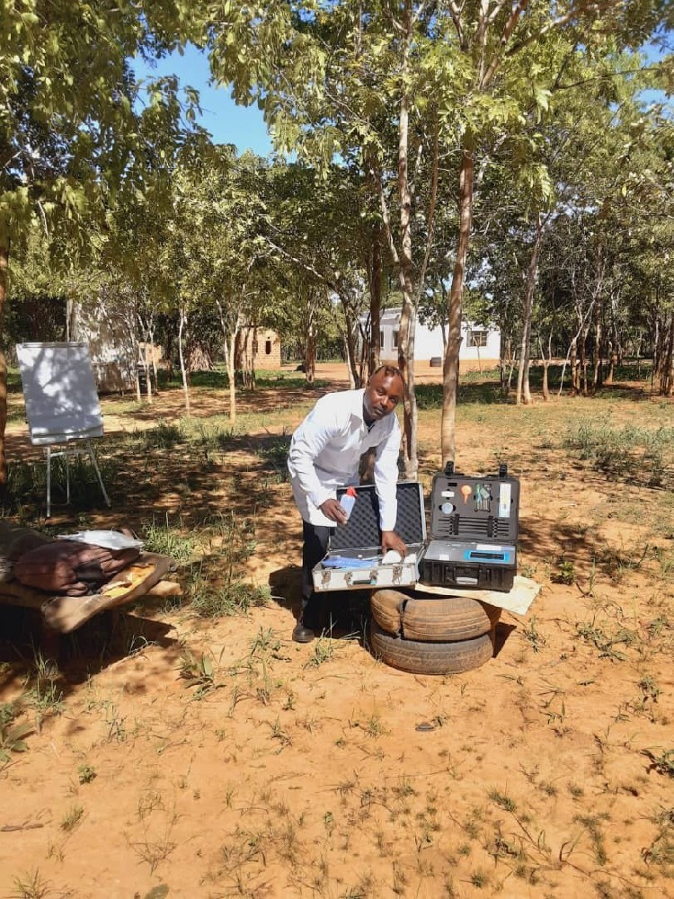 Agronomist opening HM-GT5 soil nutrient analyzer cases on a Zambian plantation