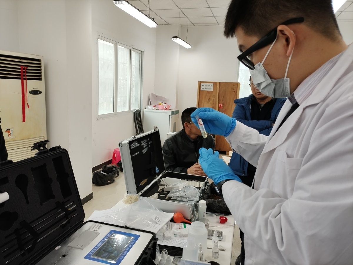 Trainer holding a sample cuvette during HM-GT3 soil nutrient analyzer training