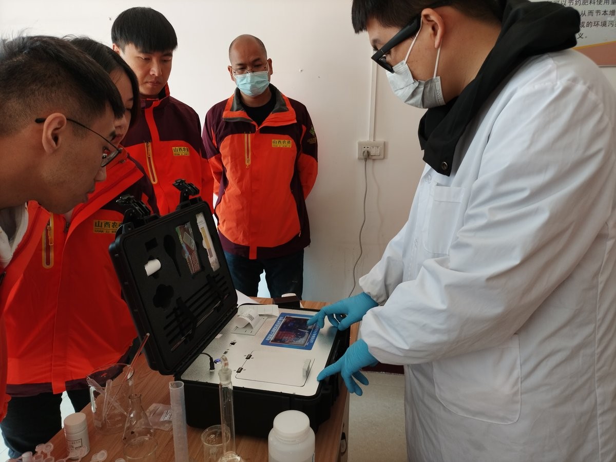 HM Instruments technician demonstrating the HM-GT5 portable soil nutrient analyzer to staff