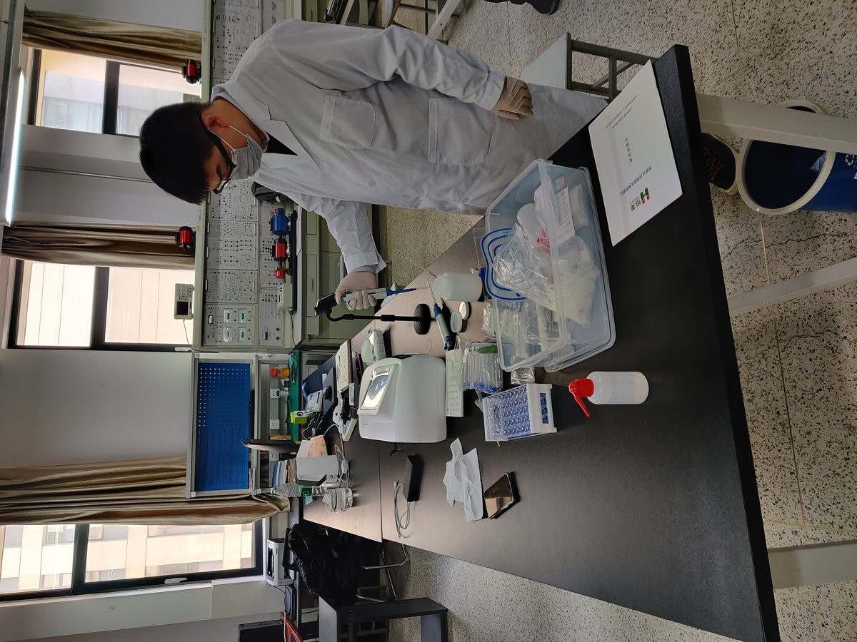 Trainer demonstrating pipette transfer technique on the HM-GT4 during university laboratory training