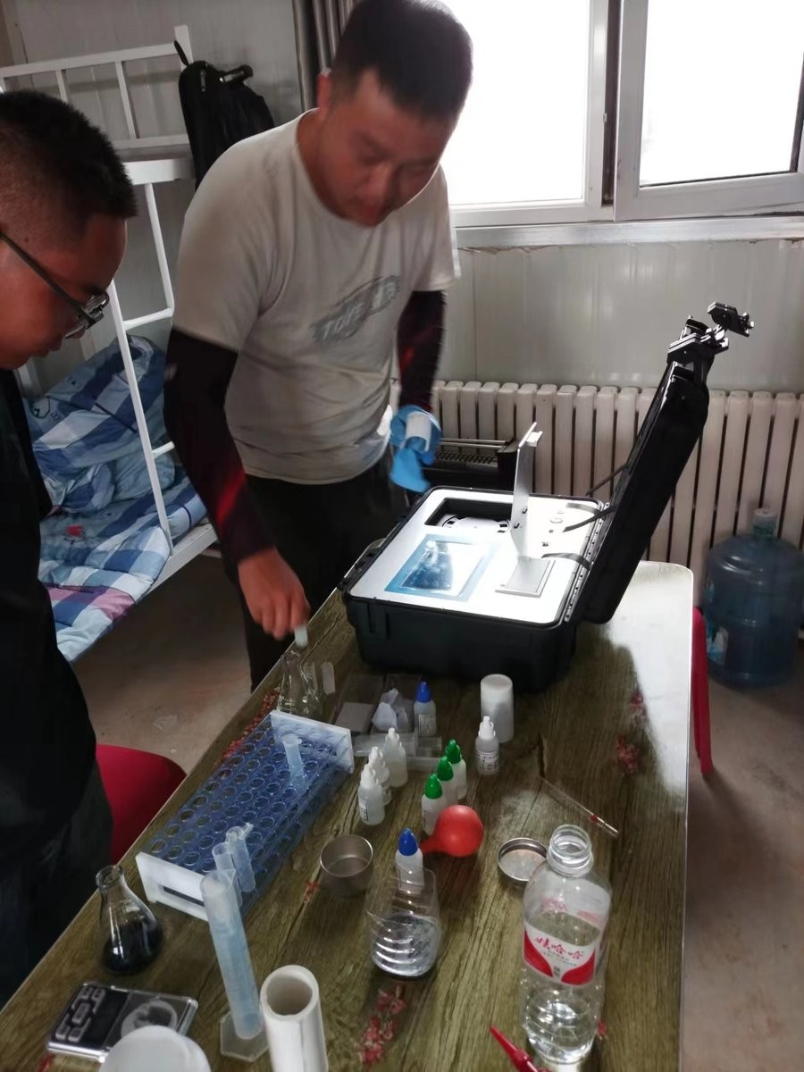 Xuechuan Agriculture trainee practicing HM-GT4 soil test procedure under instructor supervision at Gansu base farm
