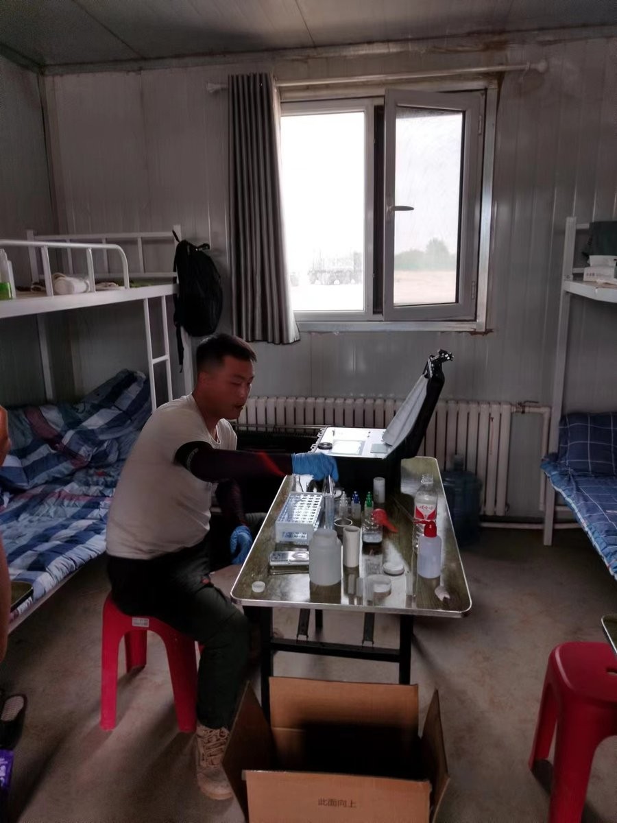 Trainee operating HM-GT4 touchscreen during soil analysis practice at Xuechuan Agriculture Group field quarters in Gansu