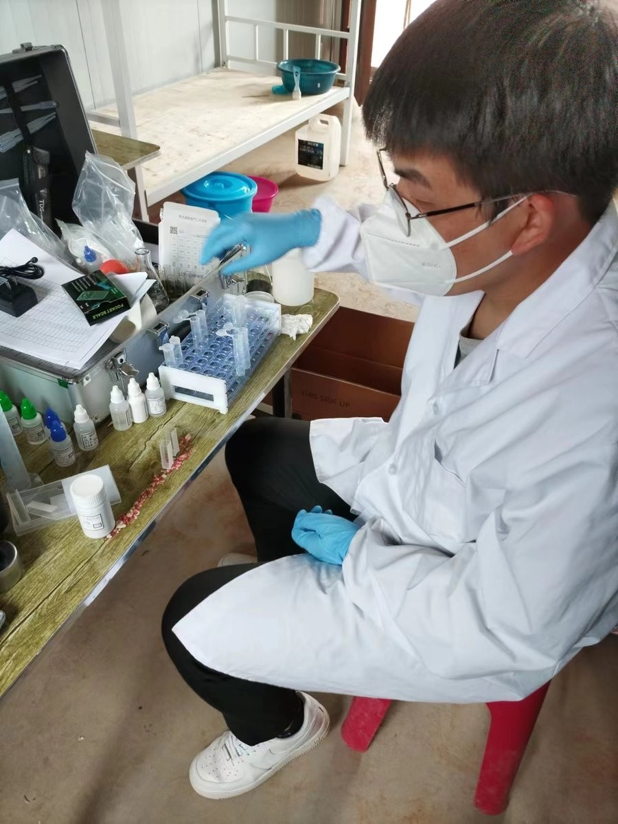 Instructor demonstrating test tube rack handling during HM-GT4 soil analysis training at Xuechuan Agriculture Group