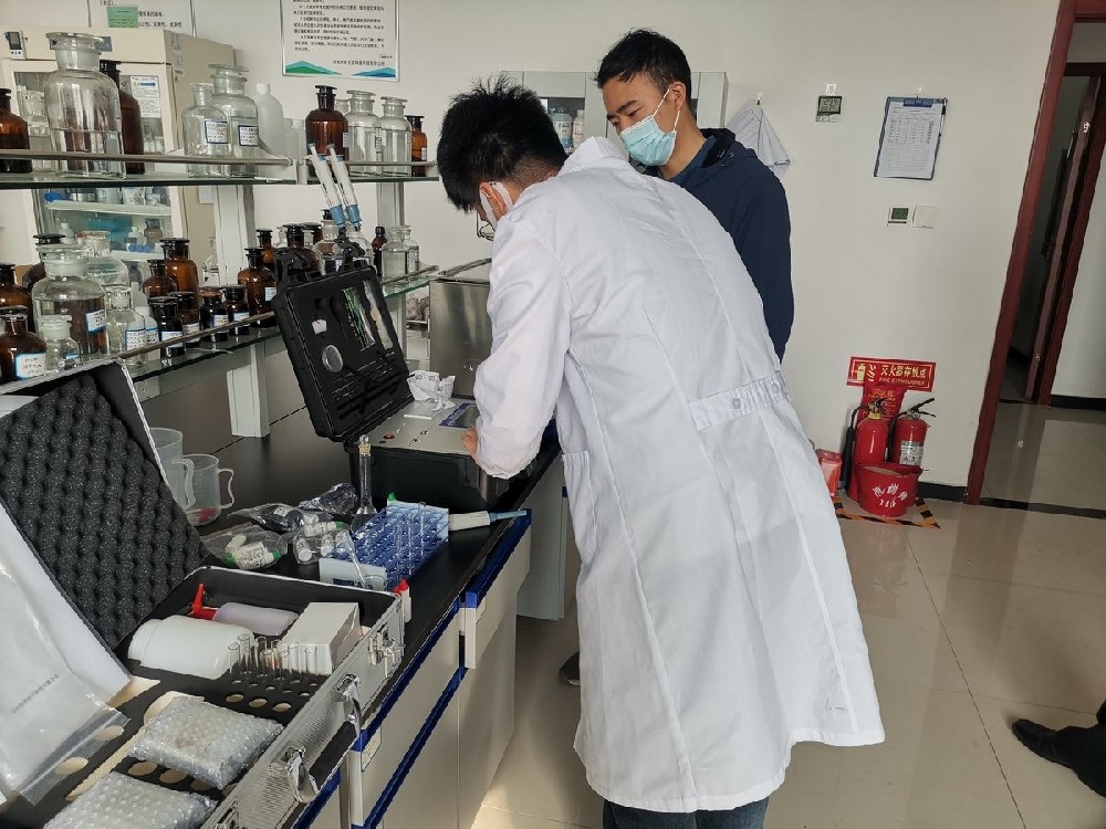 Instructor demonstrating HM-ZSD soil heavy metal detector operation to trainees at Puyang Environmental Monitoring Centre laboratory in Henan Province