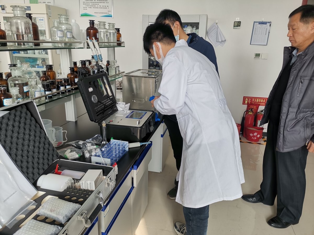 Group training session showing instructor demonstrating HM-ZSD soil heavy metal analyzer to multiple staff members at Puyang Environmental Monitoring Centre
